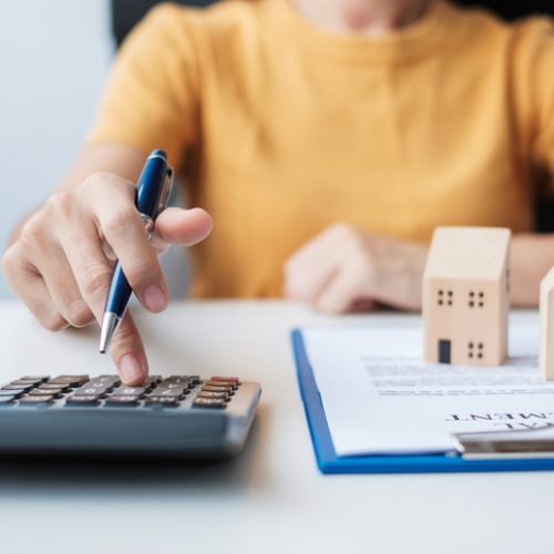 Woman using calculator during signing home contract documents. Contract agreement, real estate, buy and sale and insurance concepts Woman using calculator during signing home contract documents. Contract agreement, real estate, buy and sale and insurance concepts